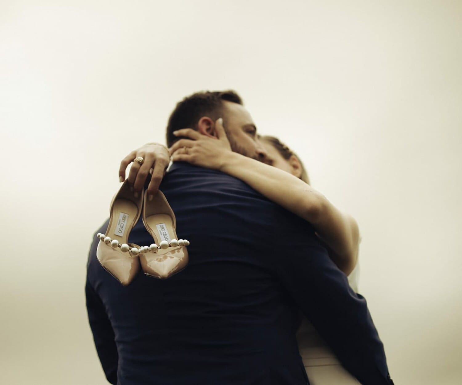 Les mariés enlacés, chaussures à la main, mariage inspiration Dolce Vita