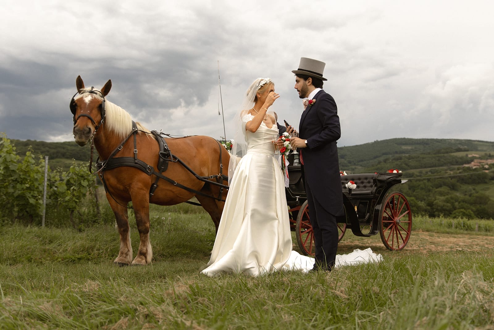 Les mariés échangent un moment tendre près d’un cheval attelé, dans les vignes – photo @castillealma