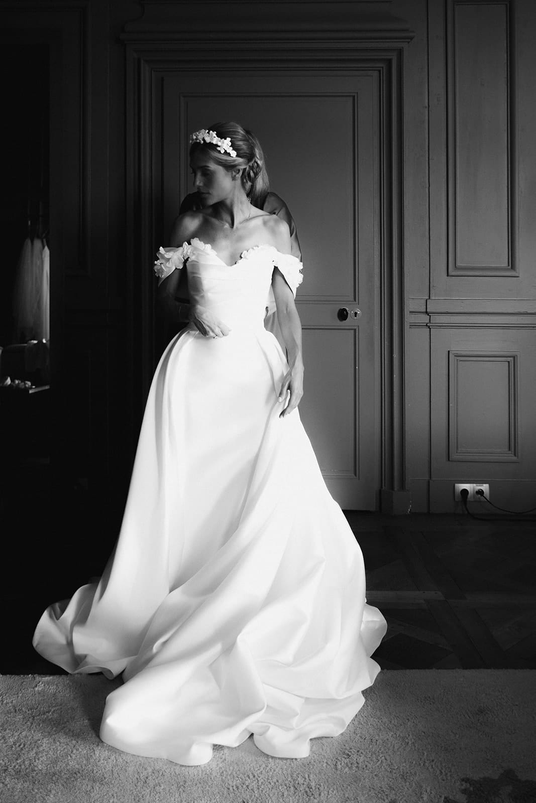 Mariée dans sa robe blanche, éclairée par la lumière naturelle, dans une chambre du Château de Pierreclos – photo @castillealma