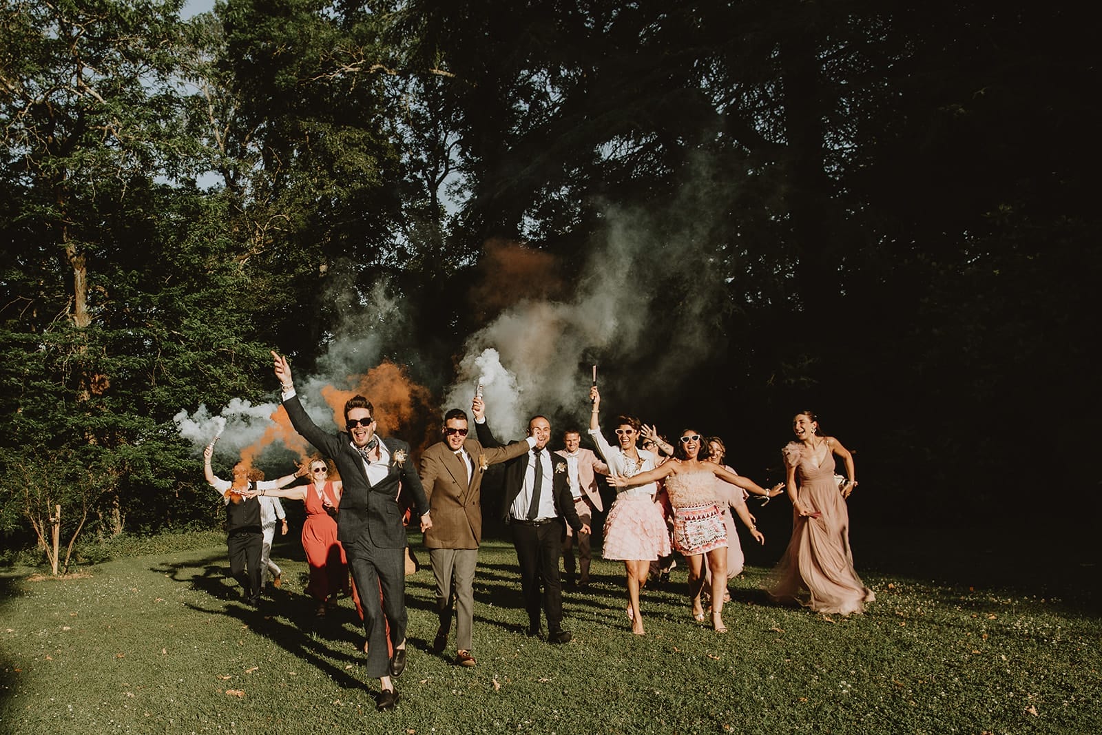 Cortège de mariés et d’invités avec des fumigènes colorés