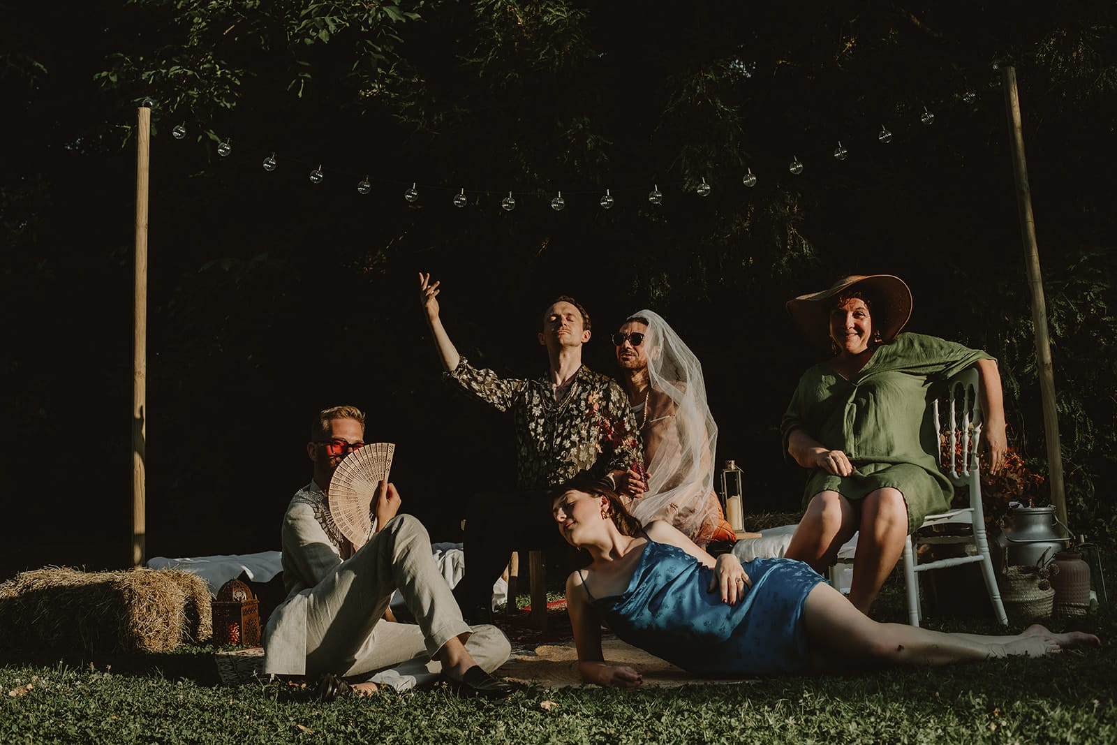 Groupe d’invités en pleine pose décalée dans un photobooth en extérieur