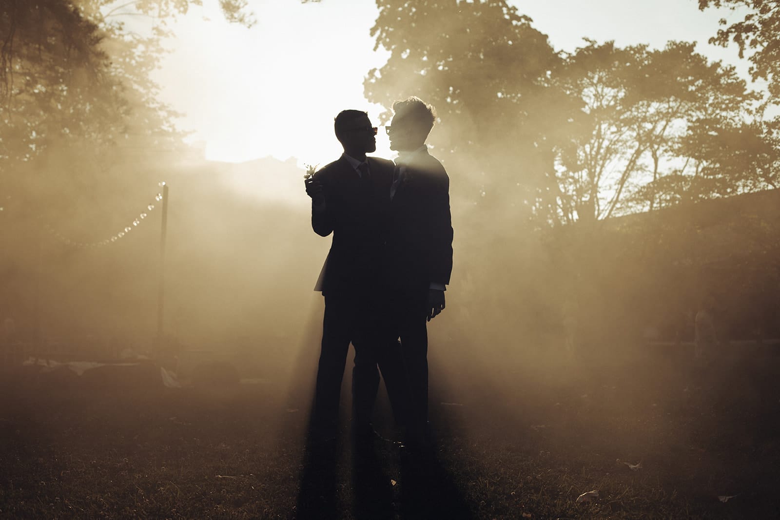 Deux mariés en contre-jour dans une brume dorée