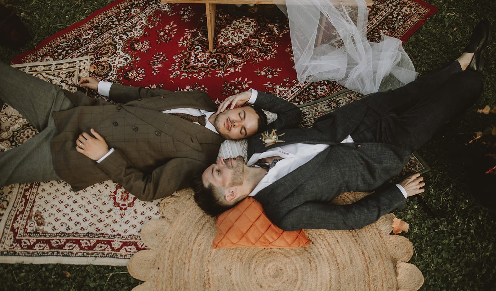 Two grooms lying together after their destination wedding ceremony in France