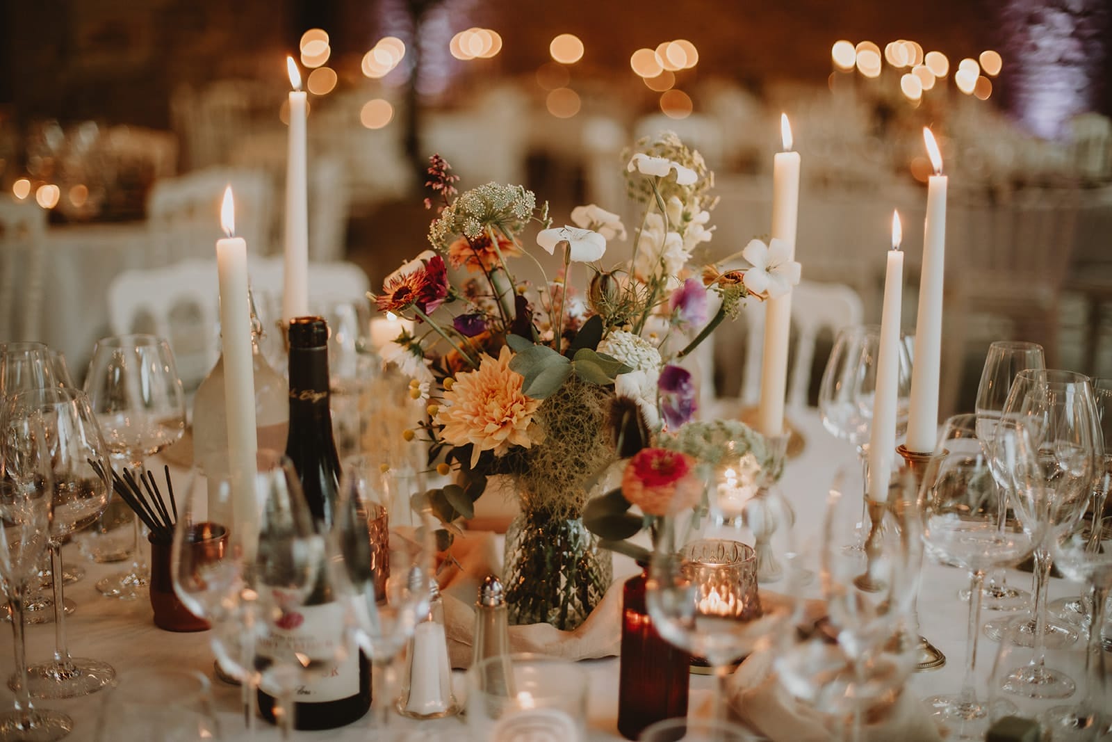 Une table de mariage décorée de fleurs et de bougies, créant une ambiance chaleureuse.