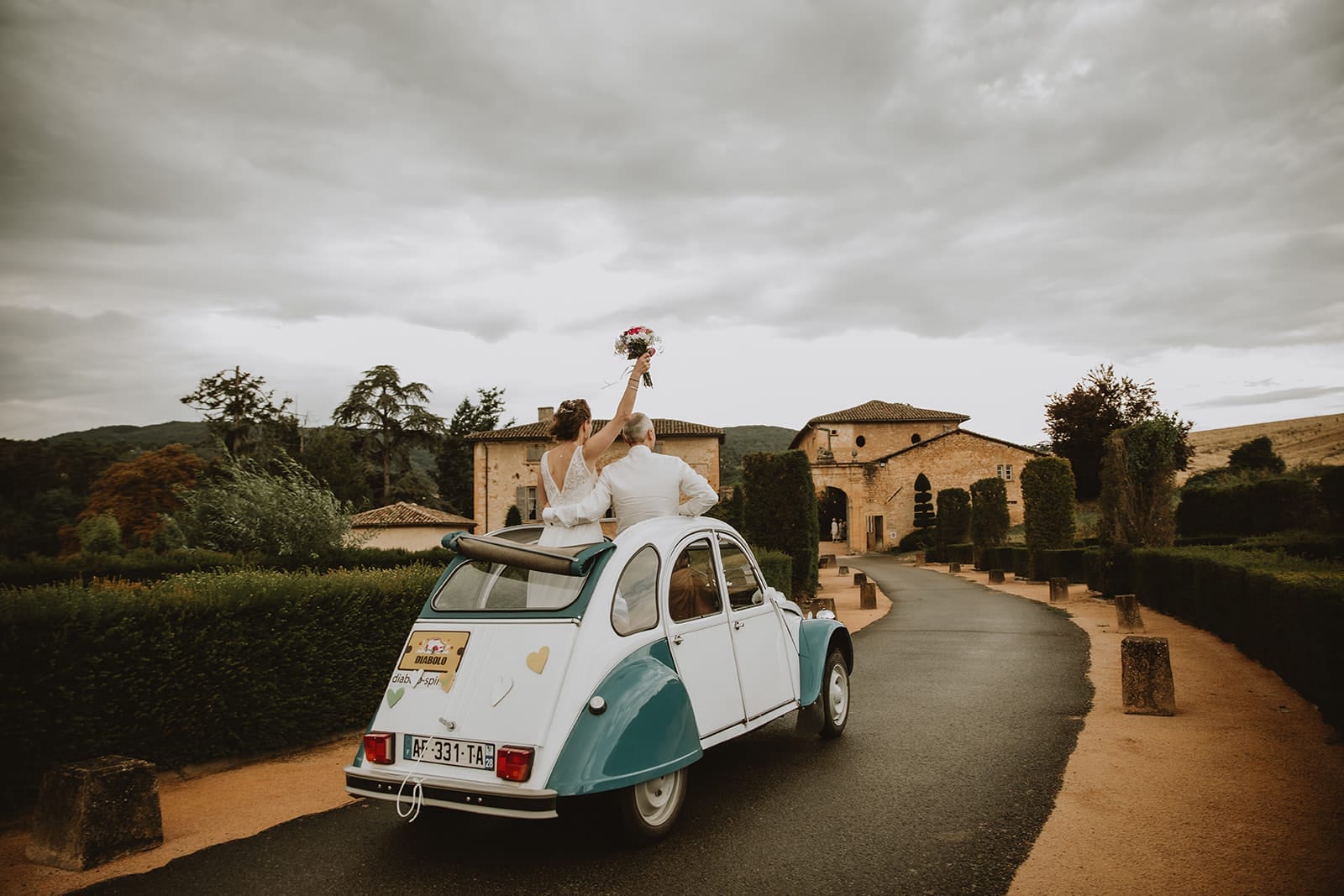 Mariés quittant le Manoir de la Garde en 2CV après leur mariage à Ville-sur-Jarnioux
