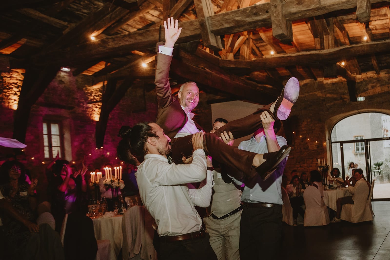 Le marié porté en l’air par ses amis pendant la soirée de mariage au Manoir de la Garde