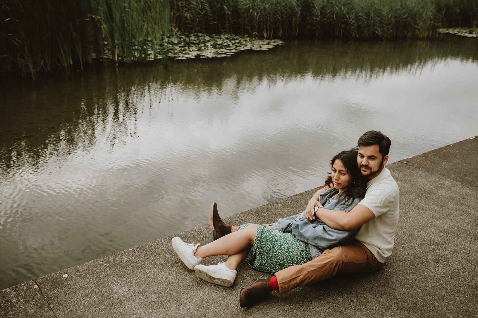 Couple assis au bord de l’eau pendant une séance engagement à Lyon