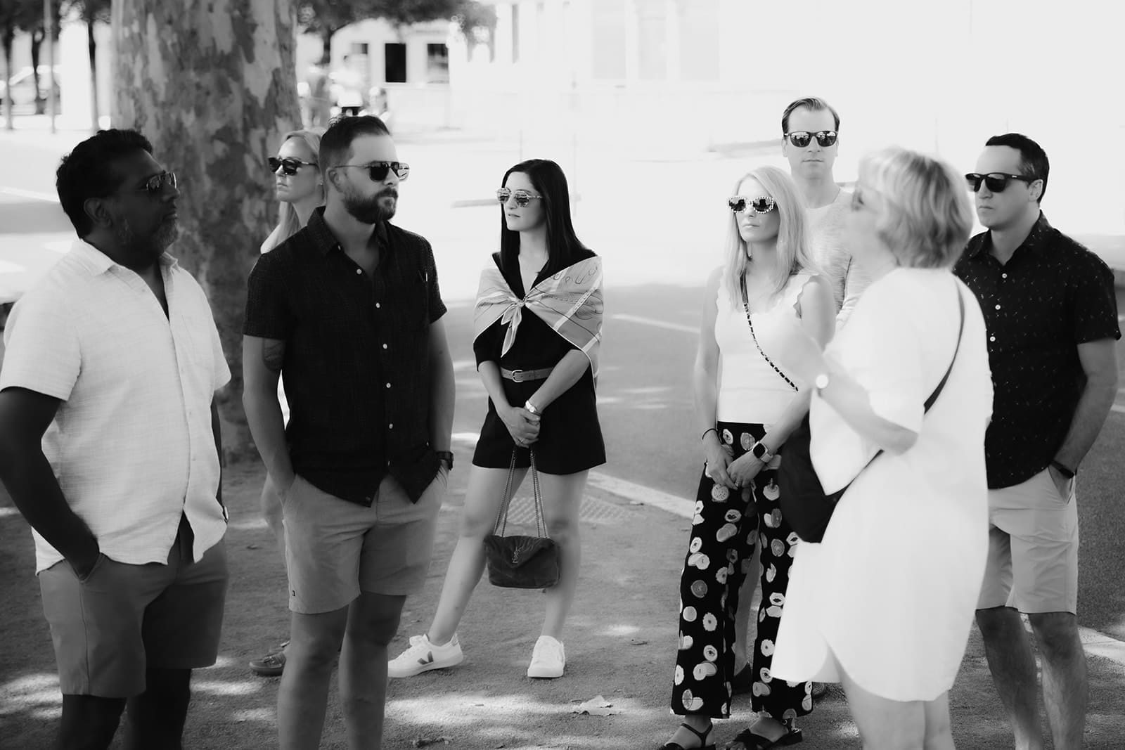 Wedding guests gathered for a city tour under the shade of the trees in Lyon
