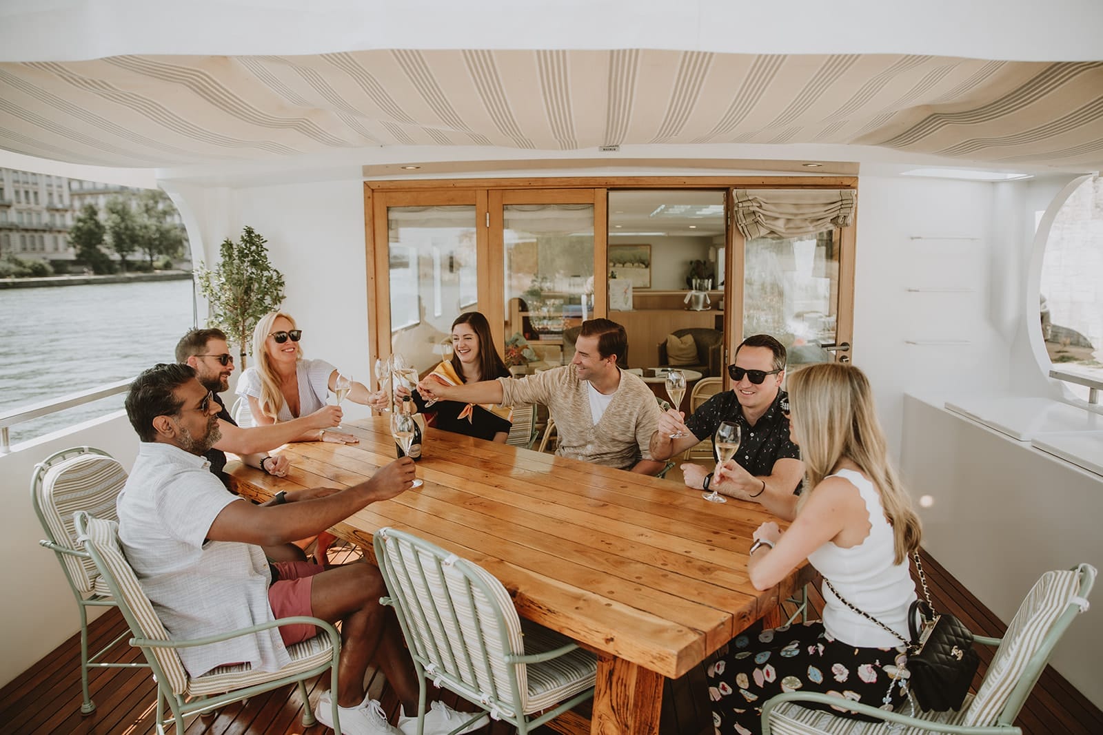 Group of friends toasting with champagne on the deck of the Belmond Lilas