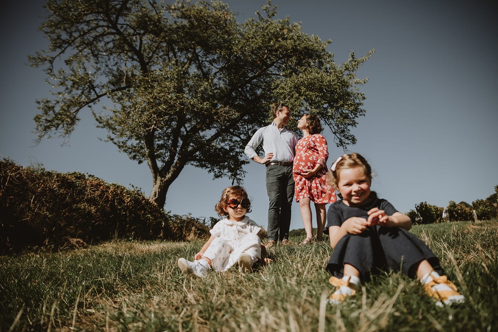 Une famille heureuse posant dans un parc ensoleillé à Lyon.