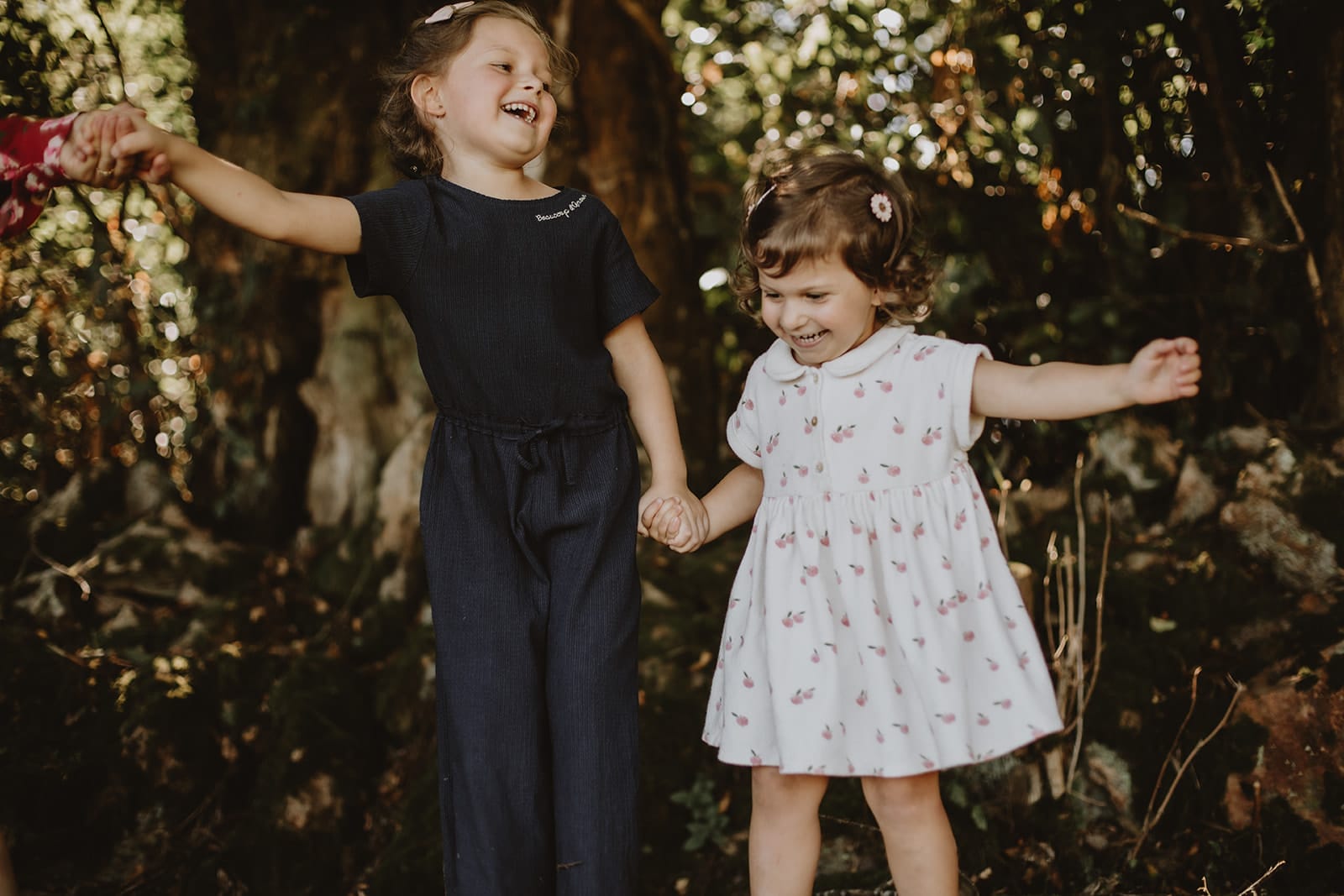 Deux petites filles s'amusent en se tenant par la main dans un cadre naturel.