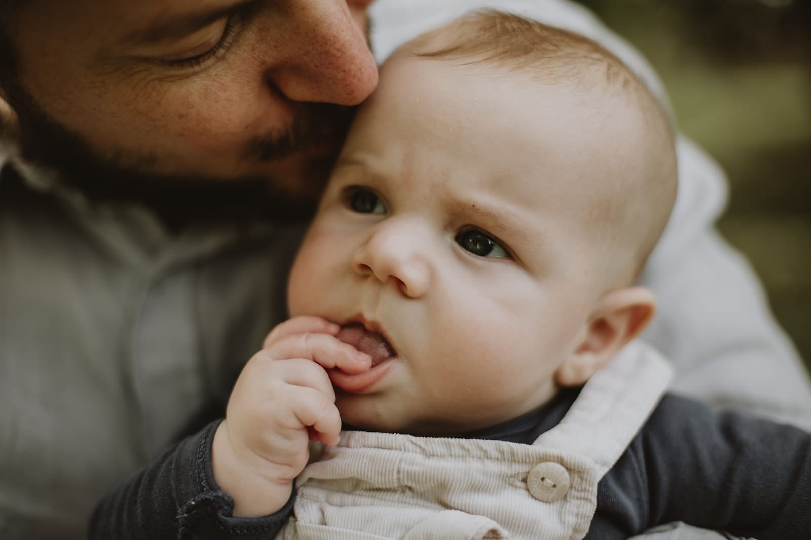 Un père embrasse son bébé, capturant un instant de douceur.