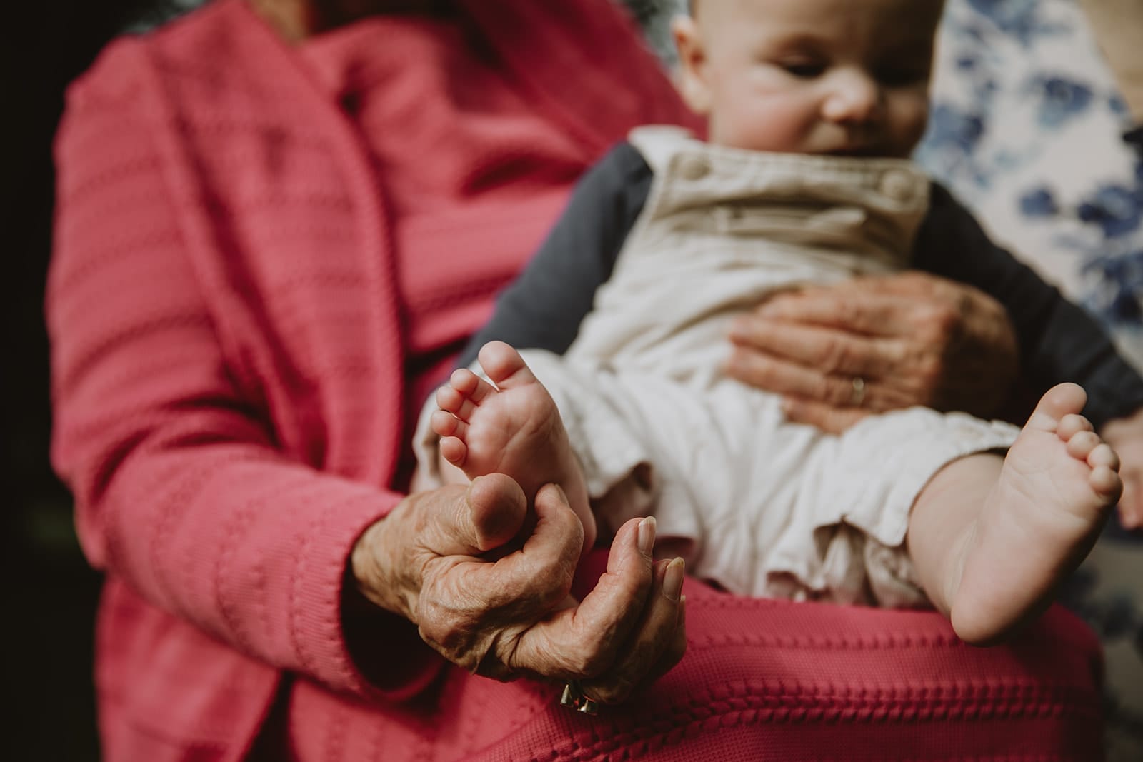 Un grand-parent tient tendrement un bébé dans ses bras.