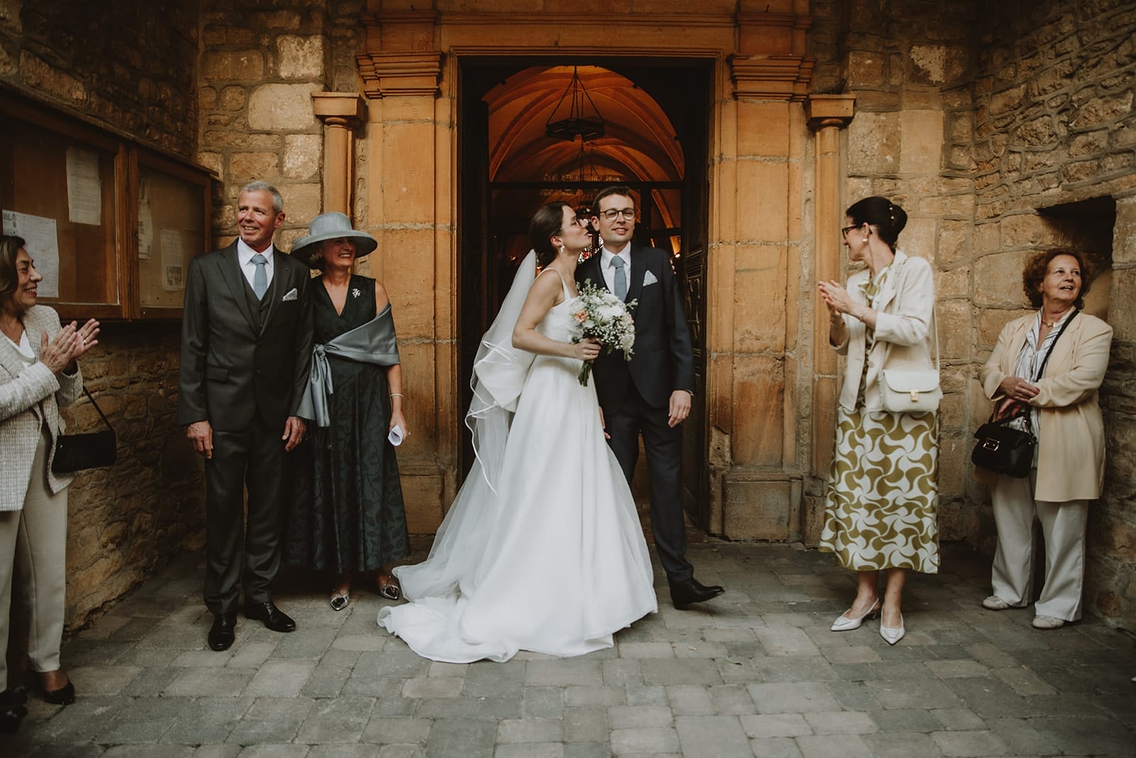 Un couple heureux s'embrasse devant leurs invités au Manoir de la Garde.