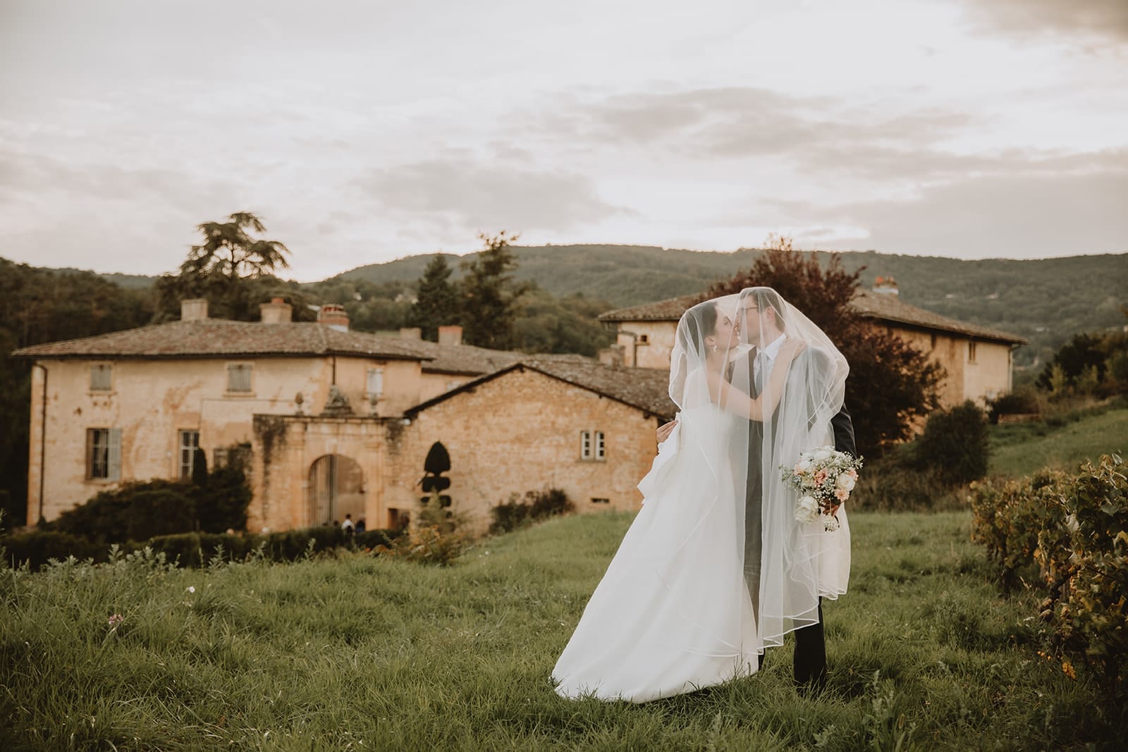 Un couple s'embrasse sous un voile au Manoir de la Garde, Lyon.