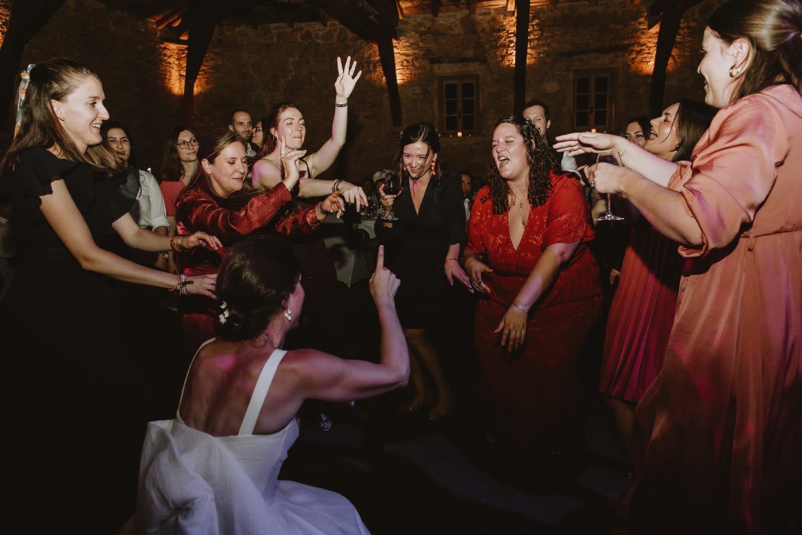Un groupe de femmes danse joyeusement lors d'un mariage.