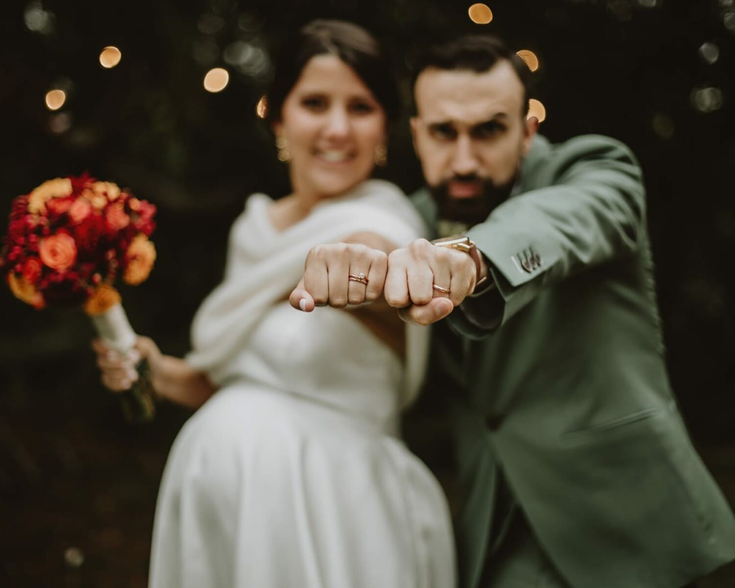 Un couple de mariés montre leurs alliances avec fierté.