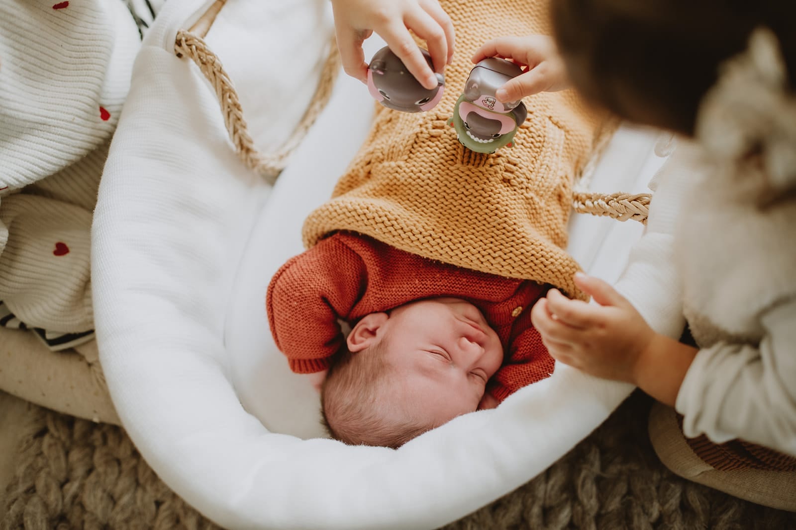 Un bébé endormi dans un cocon chaleureux, entouré de jouets.