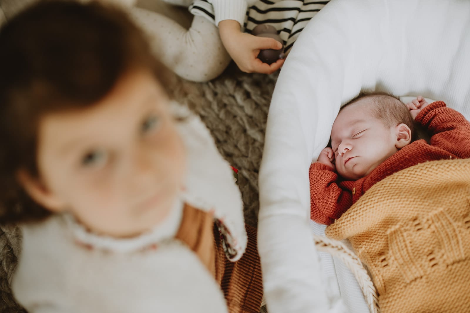 Un bébé endormi paisiblement dans un berceau, entouré de tendresse.